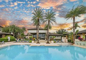 Windermere apartment for rent - a swimming pool with palm trees and a building in the background