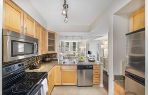 Washington apartment for rent - a kitchen with stainless steel appliances and wooden cabinets