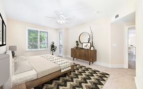 Dallas apartment for rent - a bedroom with a bed and a dresser and a ceiling fan