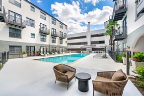 Dallas apartment for rent - A pool area with chairs and a table.
