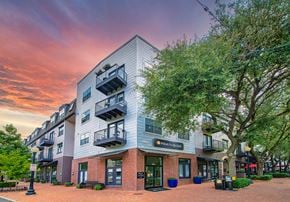 Dallas apartment for rent - a building with a tree in front of it at sunset