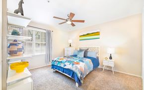 Dallas apartment for rent - a bedroom with a bed and a ceiling fan