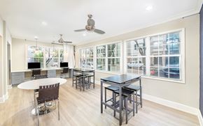 Dallas apartment for rent - a dining room with tables and chairs and a kitchen with windows