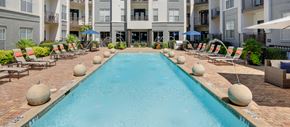 Dallas apartment for rent - a large swimming pool in front of an apartment building