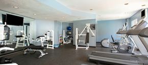 Dallas apartment for rent - a gym with various exercise equipment and a tv