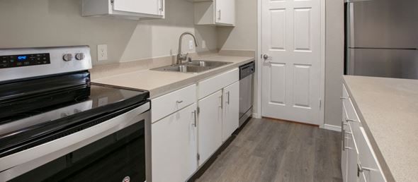 Dallas apartment for rent - an empty kitchen with white cabinets and stainless steel appliances