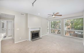 Addison apartment for rent - an empty living room with a fireplace and a ceiling fan