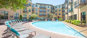 Frisco apartment for rent - an outdoor pool with lounge chairs next to an apartment building