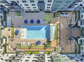 Dallas apartment for rent - an aerial view of a swimming pool in a hotel complex with other buildings