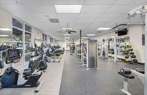 Houston apartment for rent - a gym with cardio equipment and weights on the floor
