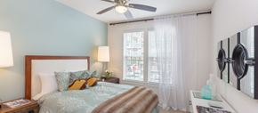 Houston apartment for rent - a bedroom with a large bed and a ceiling fan