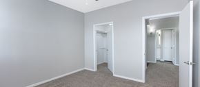 Plano apartment for rent - a bedroom with white walls and a closet and a door to a hallway