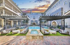 Plano apartment for rent - a courtyard with a pool and lounge chairs in front of a building