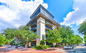 Dallas apartment for rent - an office building on the corner of a street with trees