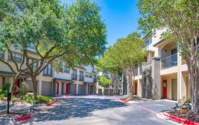 Austin apartment for rent - an empty street with apartment buildings and trees