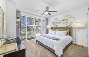 Austin apartment for rent - A bedroom with a large bed and a ceiling fan.