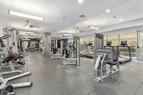 Austin apartment for rent - A spacious gym with various exercise equipment and a tiled floor.