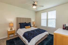 Austin apartment for rent - a bedroom with a large bed and a ceiling fan