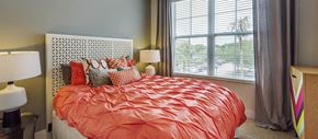 Tampa apartment for rent - a bedroom with an orange bed and a window