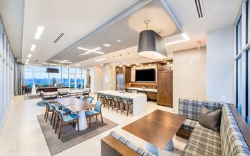 Atlanta apartment for rent - a large living room with tables and chairs and a television