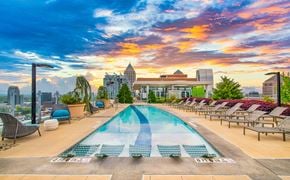 Atlanta apartment for rent - a swimming pool at the top of a building with a sunset in the sky