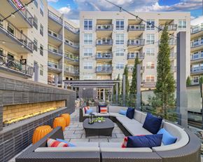 Denver apartment for rent - an outdoor patio with a couch and table in front of an apartment building