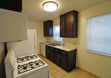 Minneapolis apartment for rent - A kitchen with a white stove and black cabinets.