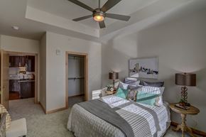 Sun Prairie apartment for rent - a bedroom with a large bed and a ceiling fan