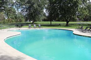 East Stroudsburg apartment for rent - a swimming pool with chairs and trees in the background