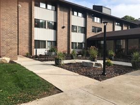 Manitowoc apartment for rent - a sidewalk in front of a brick building