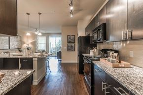 Littleton apartment for rent - A modern kitchen with dark wood cabinets and granite countertops.