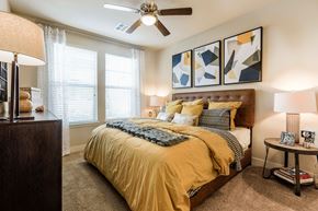 Littleton apartment for rent - A bedroom with a bed, a ceiling fan, and a window with blinds.