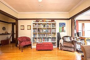 Chicago apartment for rent - A living room with a bookshelf, a red chair, a grey armchair, and a red ottoman.