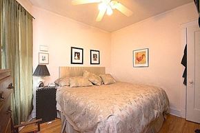 Chicago apartment for rent - A bedroom with a bed, nightstand, and pictures on the wall.