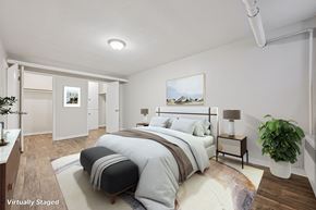 Denver apartment for rent - A bedroom with a large bed and a painting on the wall.