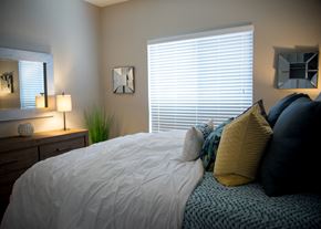Folsom apartment for rent - a bedroom with a bed with pillows and a dresser and a window