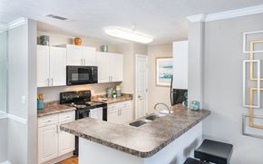 Duluth apartment for rent - a kitchen with white cabinets and a granite counter top