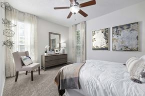 Duluth apartment for rent - an expansive bedroom with a large bed and a ceiling fan