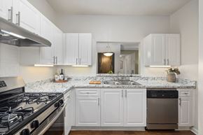 Duluth apartment for rent - an open kitchen with white cabinets and granite counter tops