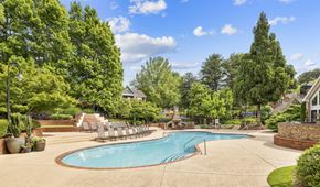 Duluth apartment for rent - a swimming pool with chaise lounge chairs near trees and a house