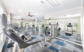 Duluth apartment for rent - a gym with weights and cardio machines and a ceiling fan