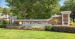 Duluth apartment for rent - a sign for the mia river place on a stone wall with flowers and trees
