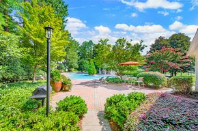 Duluth apartment for rent - the backyard has a swimming pool and a patio with a table and umbrella