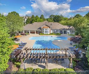 Duluth apartment for rent - an aerial view of a pool with a house in the background