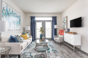 Leland apartment for rent - A living room with a white couch, a glass table, and a painting on the wall.