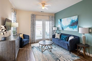 Bargersville apartment for rent - A living room with a blue couch and a painting on the wall.