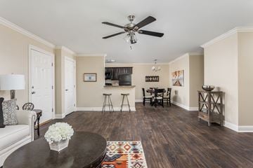 Denham Springs apartment for rent - A living room with a ceiling fan and a dining table with chairs.