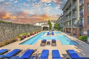 Smyrna apartment for rent - an outdoor pool with blue lounge chairs and an apartment building