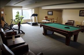 Clare townhouse for rent - A room with a pool table, treadmill, and exercise equipment.
