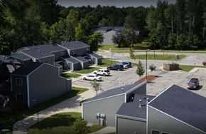 Clare townhouse for rent - A parking lot with cars and a building in the foreground.